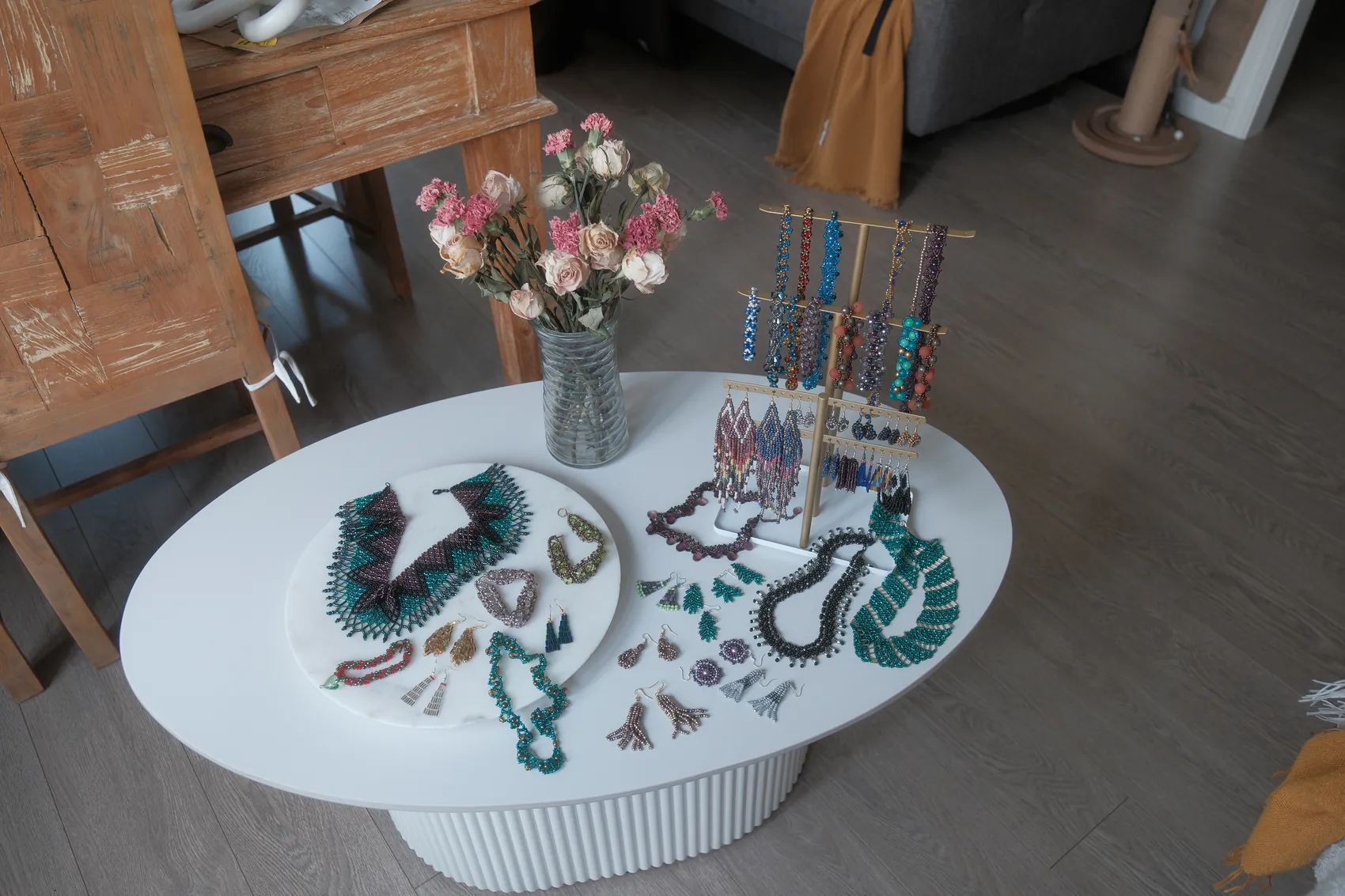 Lynn's beaded jewelry laid out on a table with flowers